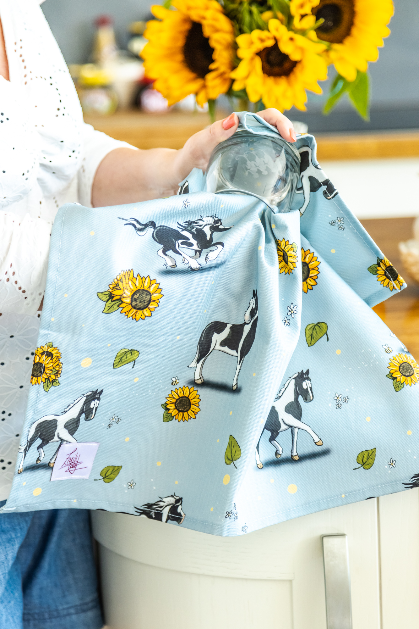 100% Cotton Tea Towel, illustrated with Piebald Horses and Sunflower details being used in a farmhouse kitchen.